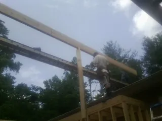 Carpenter setting a ridge beam over a new addition frame — Ice Dam Removal by Roofing Brothers in Dresden
